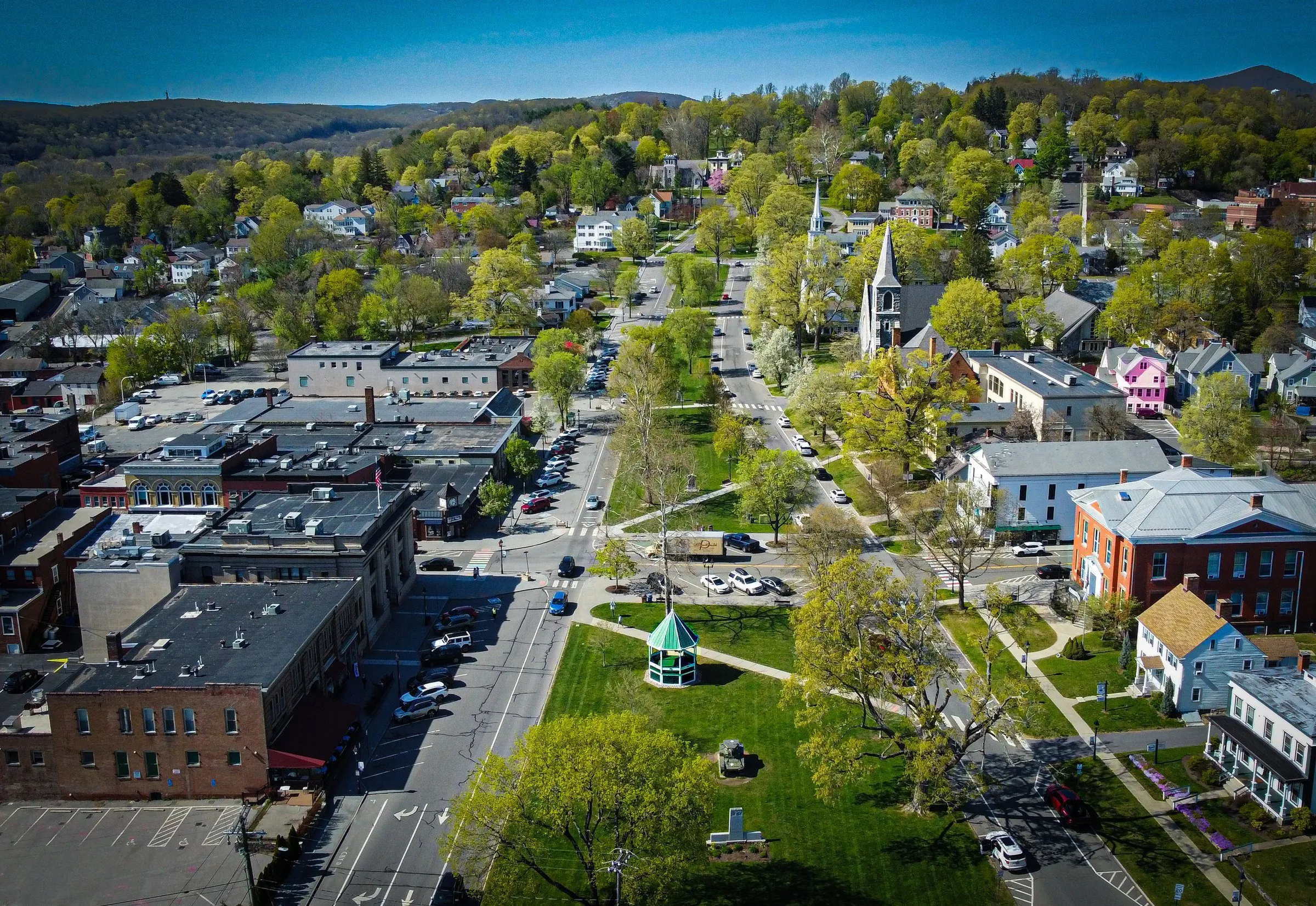 Aerial view of the long New Milford Town Green with its bandstand, church steeples, Town Hall and the hills beyond