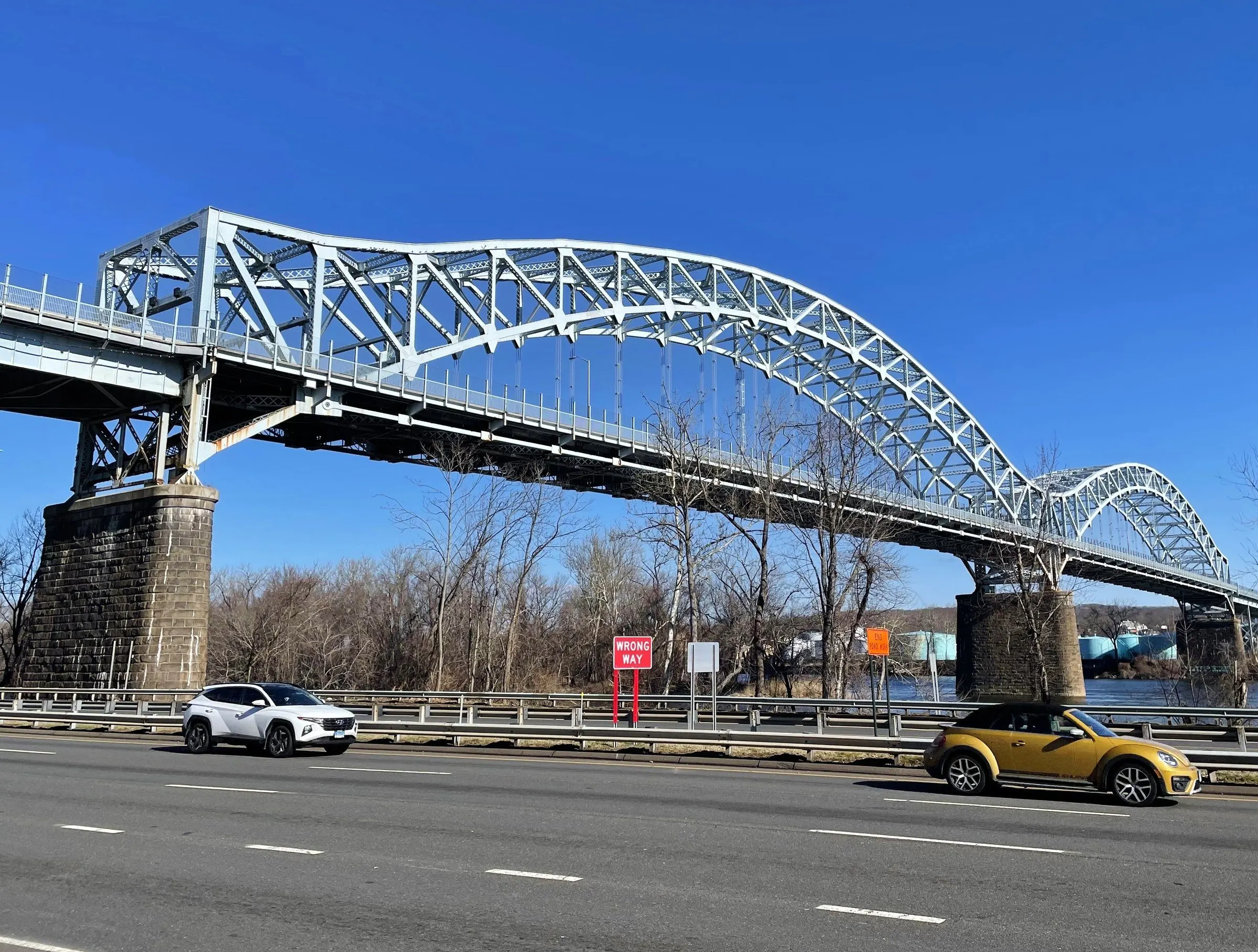 The steel double arch of the Arrigoni Bridge over the Connecticut River at Middletown, against a deep blue sky