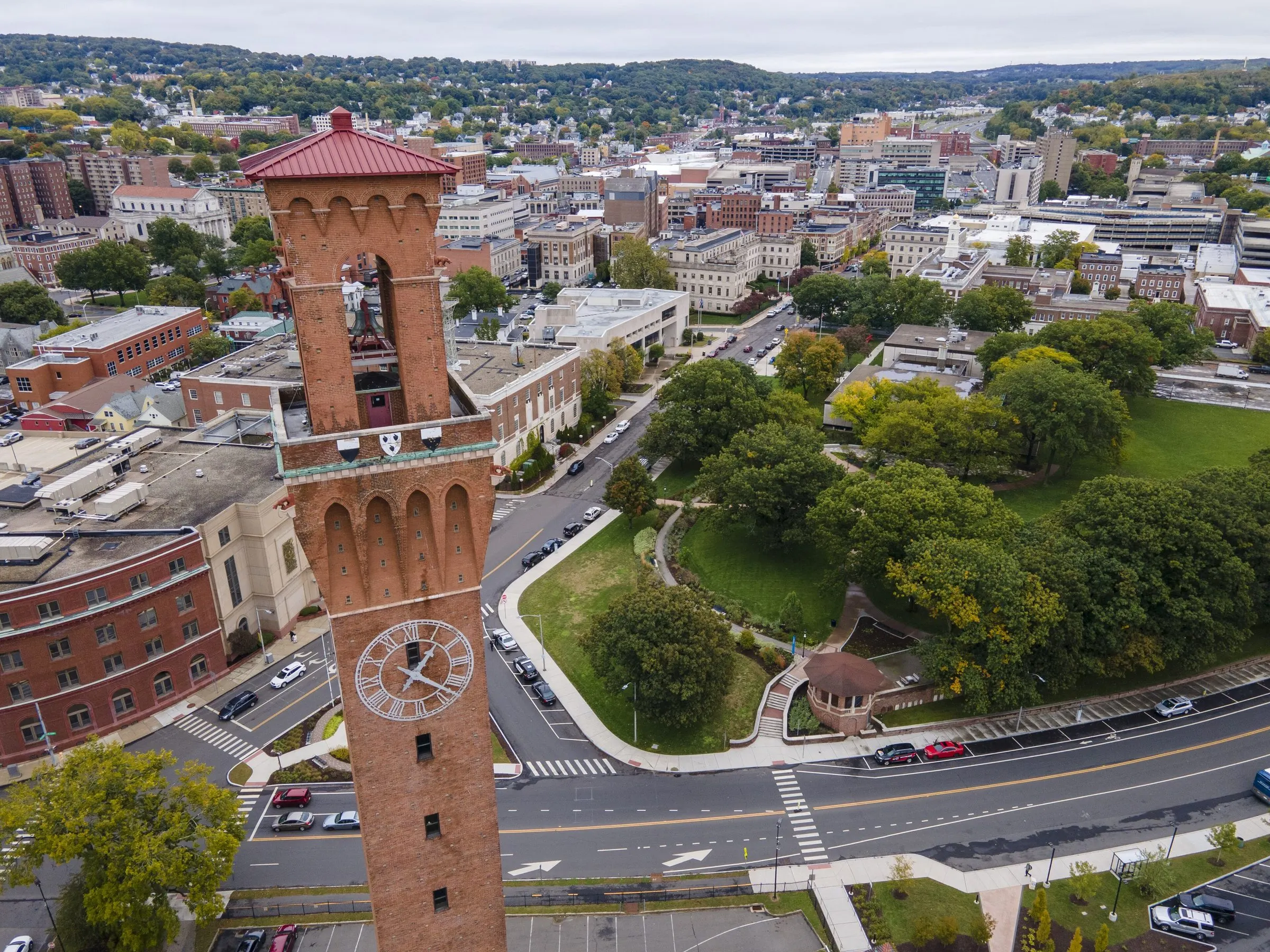 An aerial view over the Union Station clock tower, with downtown Waterbury and the hills beyond