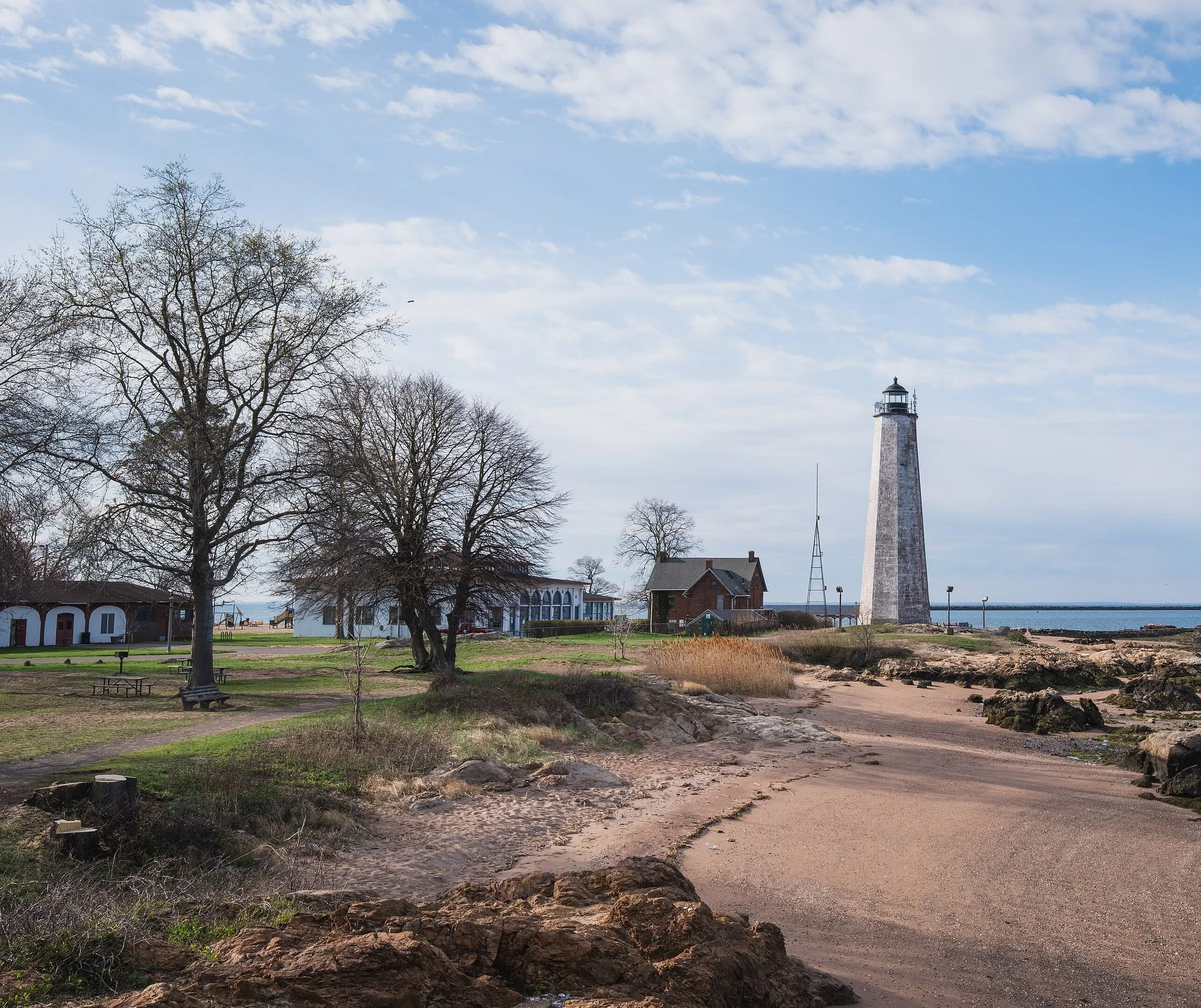 Five Mile Point Light and its brick keeper's house at Lighthouse Point Park, with the shore path leading in
